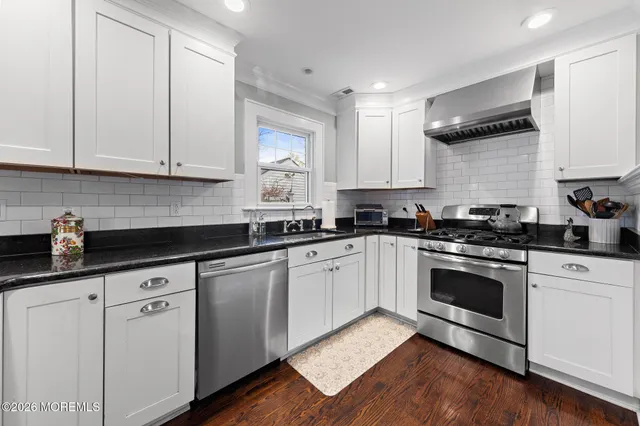 a kitchen with granite countertop white cabinets and white appliances