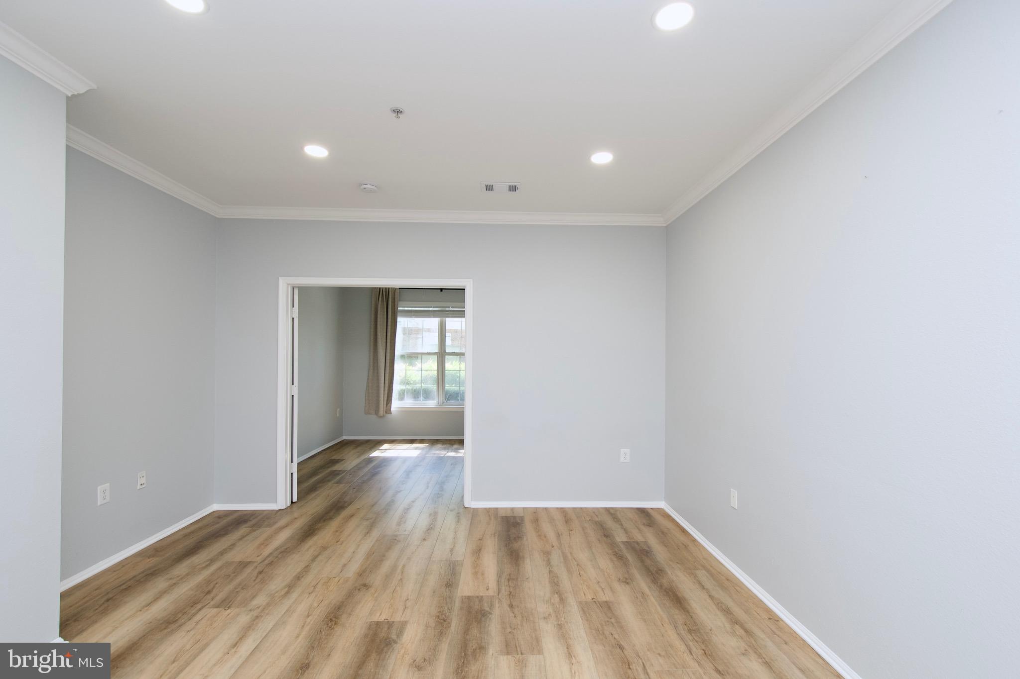 3003 Nicosh Circle, Unit 3106 Falls Church, VA 22042 - Photo 12 of 25 a view of an empty room with wooden floor and a window