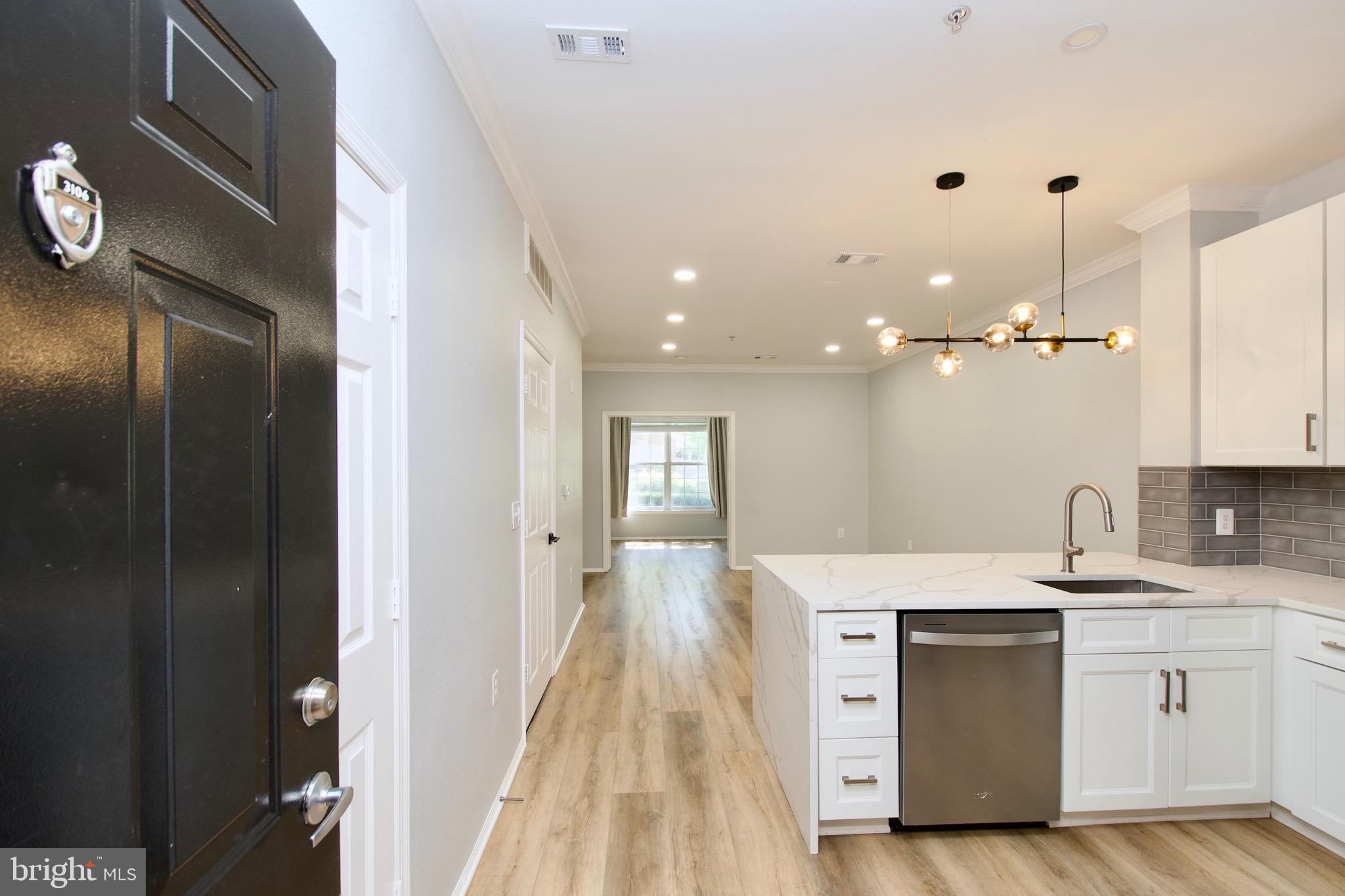3003 Nicosh Circle, Unit 3106 Falls Church, VA 22042 - Photo 3 of 25 a kitchen with a sink dishwasher a stove and a refrigerator with wooden floor