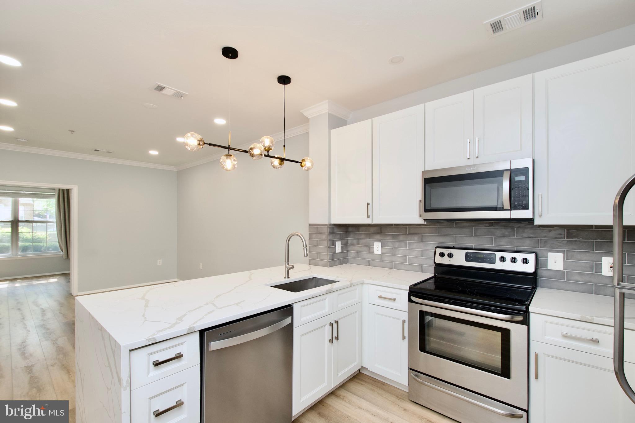 3003 Nicosh Circle, Unit 3106 Falls Church, VA 22042 - Photo 6 of 25 a kitchen with a sink stove and microwave