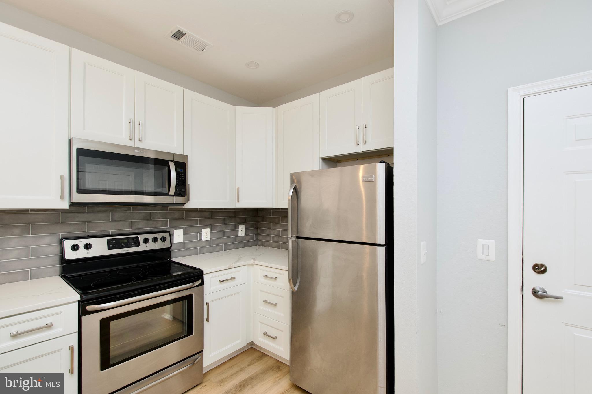 3003 Nicosh Circle, Unit 3106 Falls Church, VA 22042 - Photo 7 of 25 a kitchen with a refrigerator stove and microwave