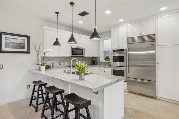 a kitchen with kitchen island white cabinets and stainless steel appliances