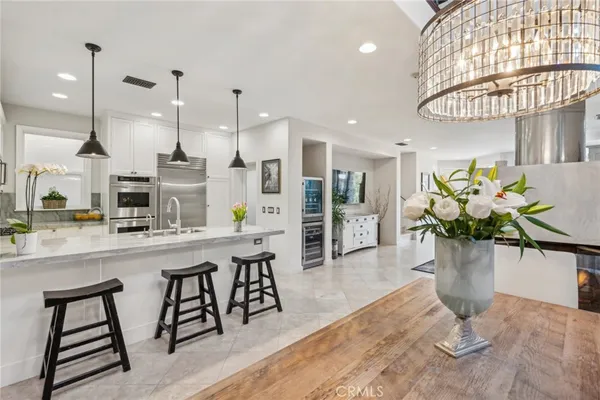 a kitchen with stainless steel appliances kitchen island granite countertop a table and chairs in it