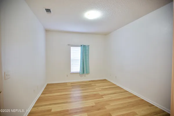 a view of a room with wooden floor and windows