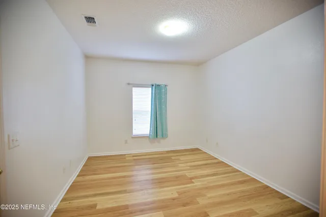 a view of a room with wooden floor and windows