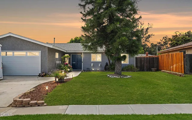 a front view of a house with a yard and garden