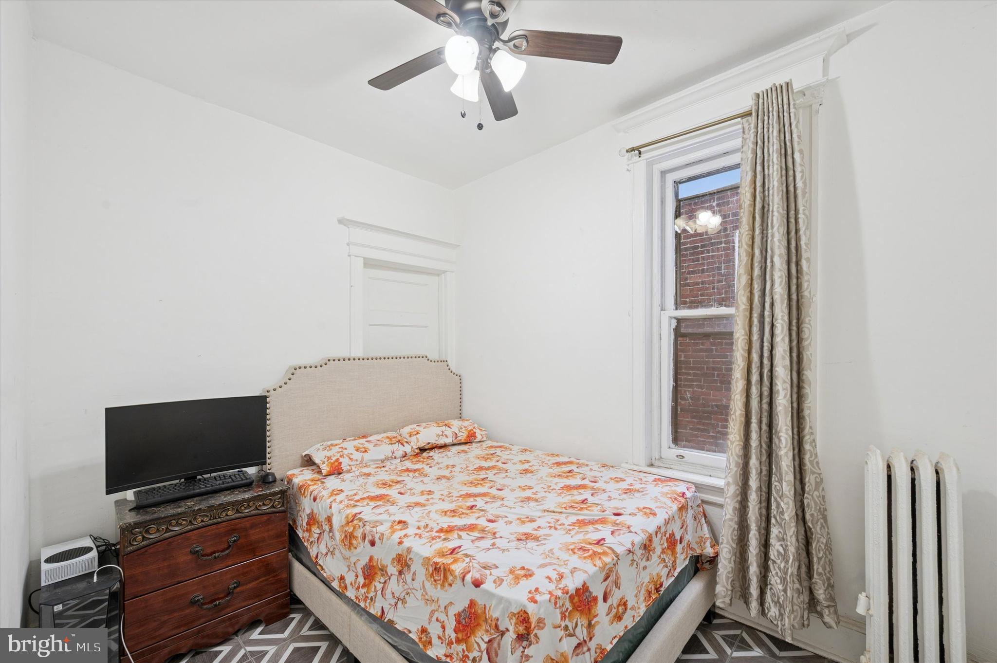 6105 Locust Street Philadelphia, PA 19139 - Photo 10 of 15 a bedroom with a bed and a flat tv screen