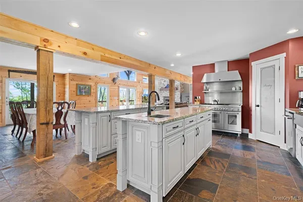 a large kitchen with stainless steel appliances kitchen island granite countertop a large counter top and sink
