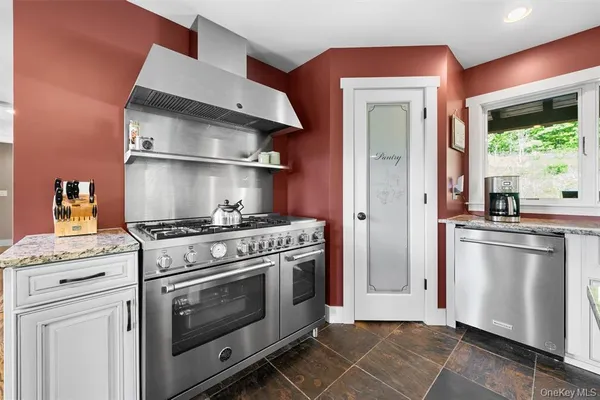 a kitchen with stainless steel appliances kitchen island granite countertop a stove and a sink