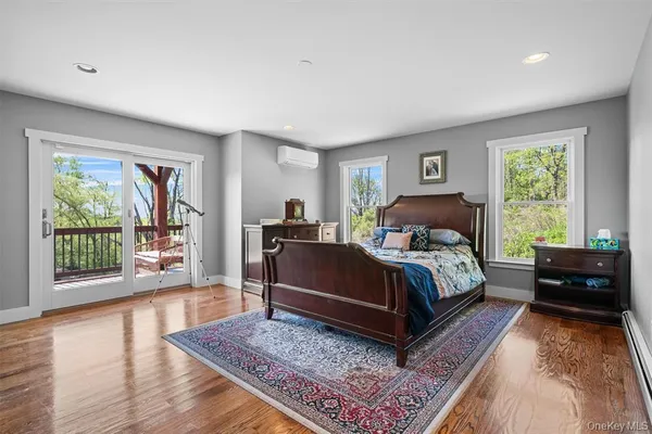a bedroom with a bed lamp on desk and a window