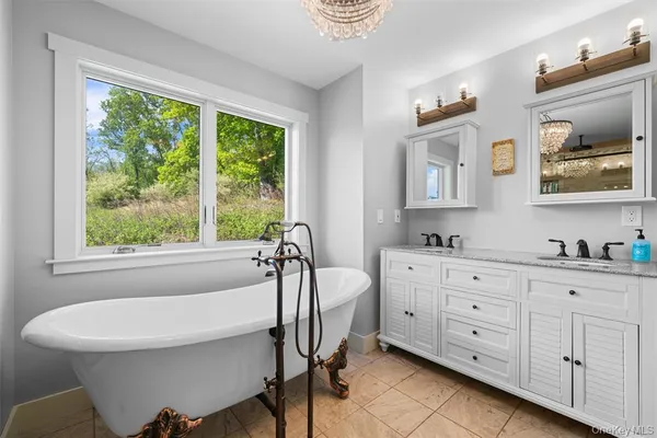 a bathroom with a tub shower and window