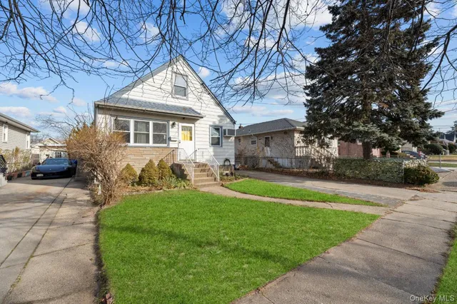 a front view of a house with a yard and trees