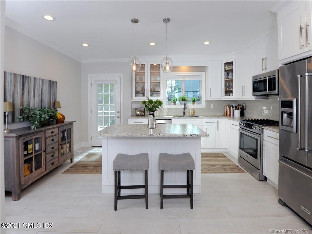 18 William Street, Unit WEST Greenwich, CT 06830 - Photo 6 of 21 a kitchen with stainless steel appliances a sink a stove a refrigerator cabinets and a dining table
