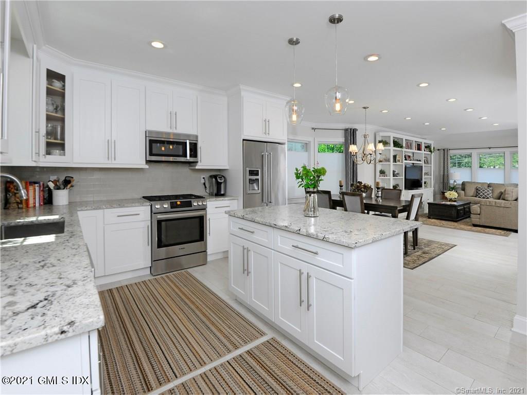 18 William Street, Unit WEST Greenwich, CT 06830 - Photo 7 of 21 a kitchen with stainless steel appliances granite countertop a stove top oven a sink dishwasher and a refrigerator with wooden floor