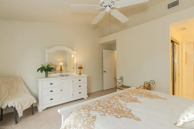 a spacious bedroom with a bed and a dresser