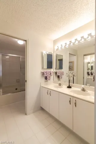 a spacious bathroom with a shower a sink and mirror