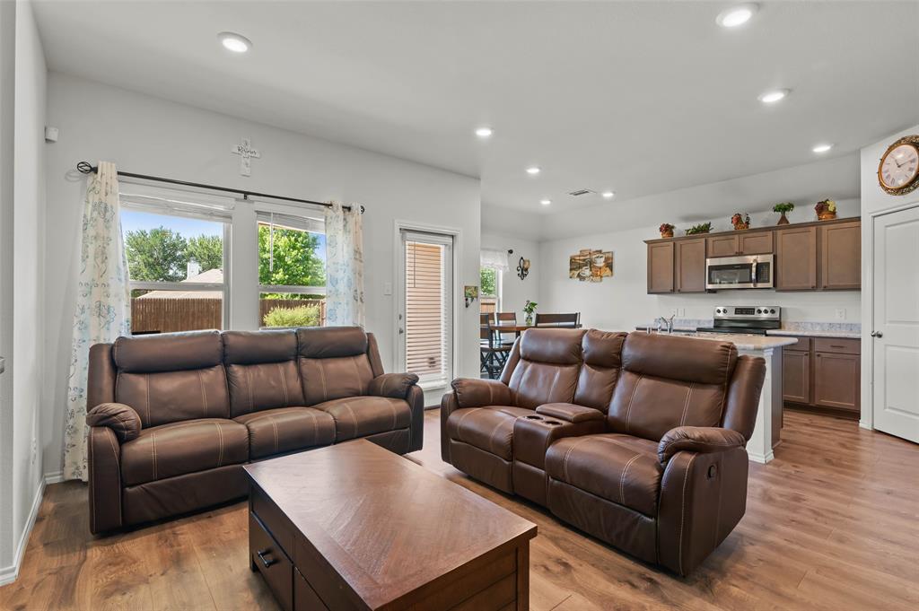 409 Wilson Way Denton, TX 76207 - Photo 2 of 33 Open-concept living area featuring wood-finish flooring, recessed lighting, and a neutral wall palette