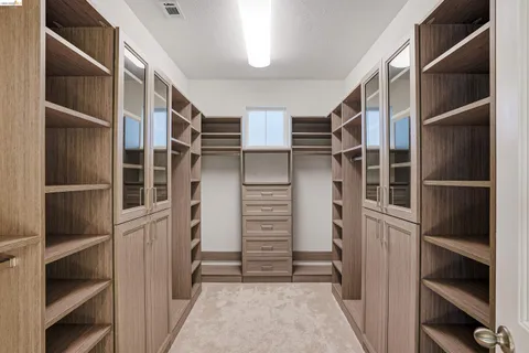 a view of walk in closet with empty racks