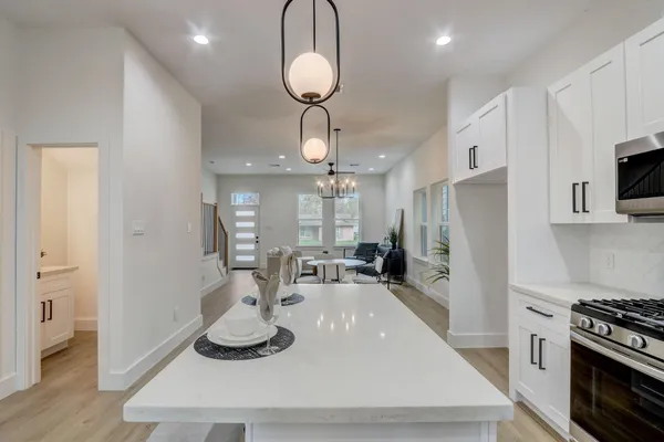 a kitchen with stainless steel appliances granite countertop a sink a stove and a refrigerator
