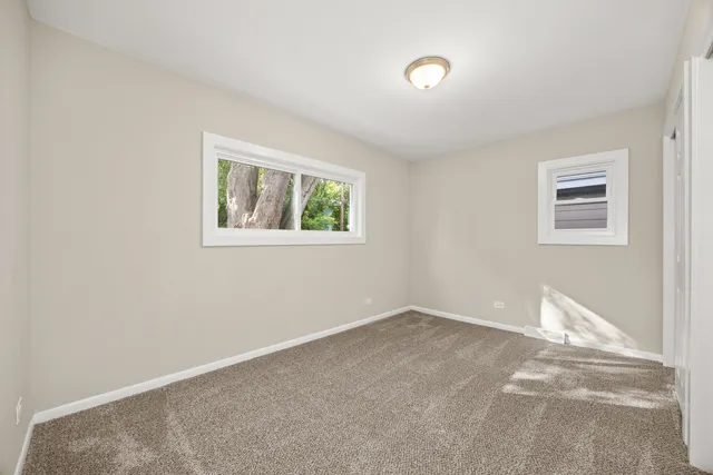 an empty room with windows and bathroom view