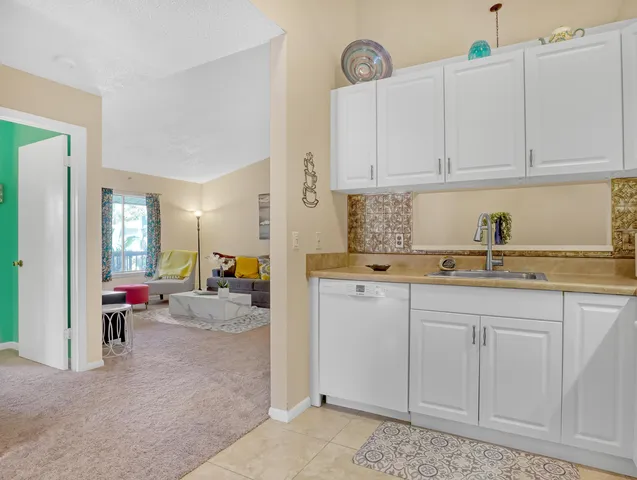 a kitchen with white cabinets and sink