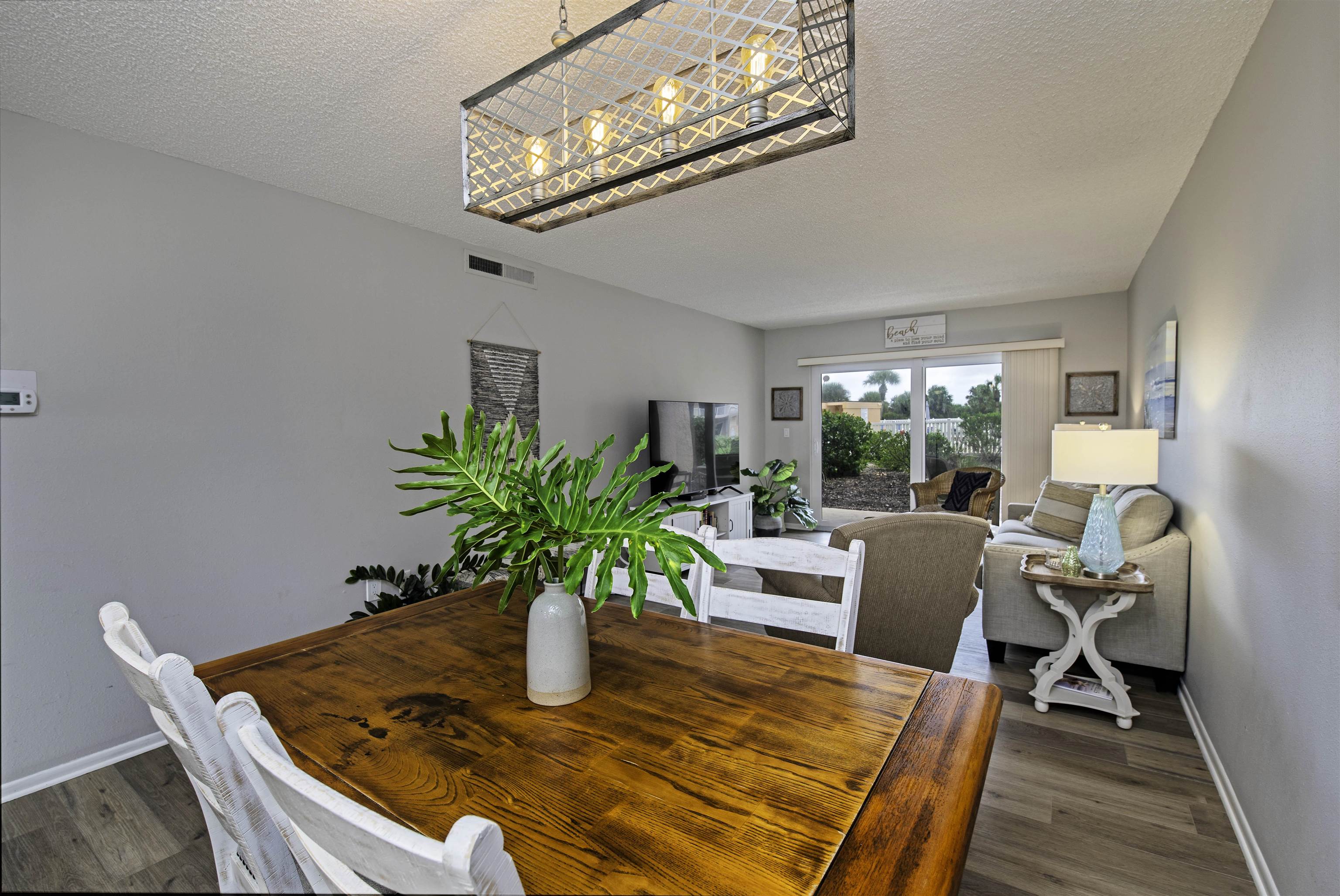 4 Ocean Trace Road, Unit 119 St. Augustine, FL 32080 - Photo 3 of 35 a dining room with furniture a potted plant and a chandelier