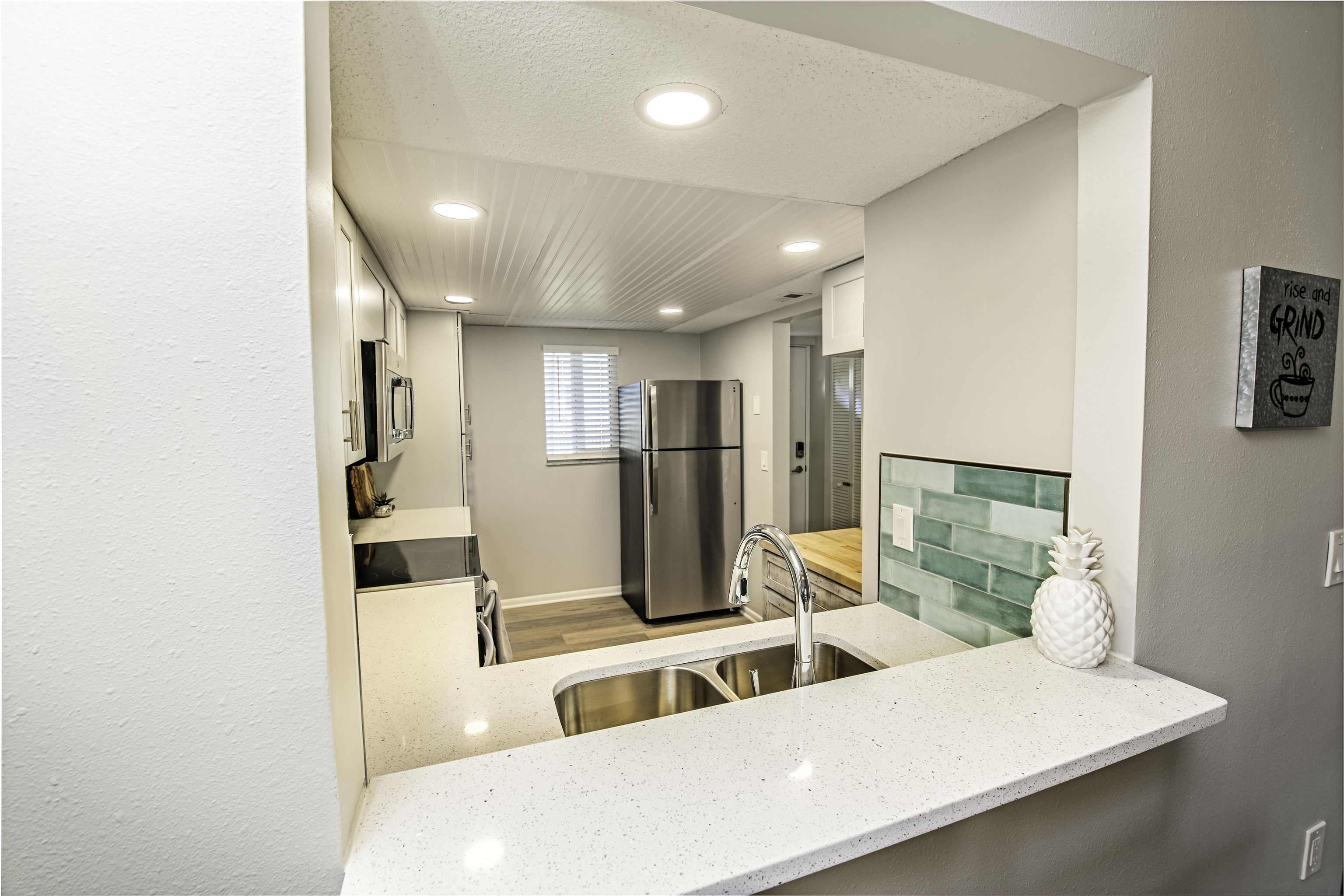 4 Ocean Trace Road, Unit 119 St. Augustine, FL 32080 - Photo 6 of 35 a living room with stainless steel appliances kitchen island granite countertop a refrigerator and a sink