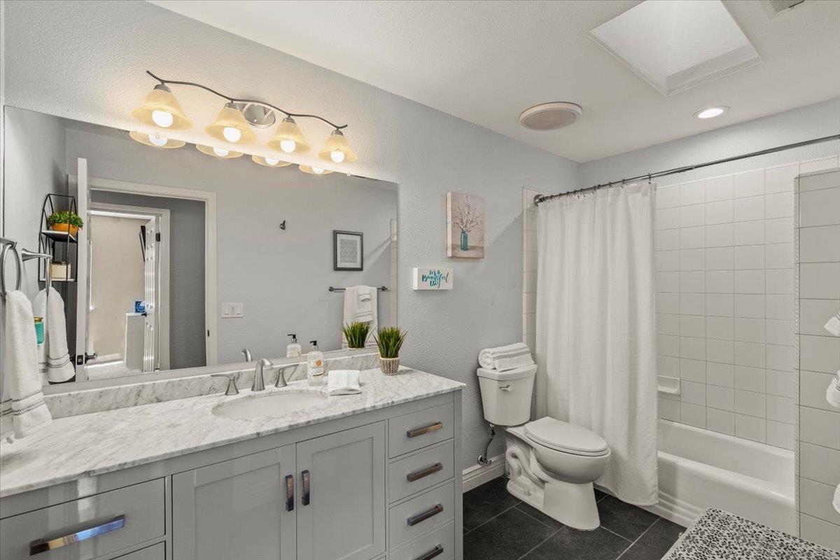 5442 Mesa Road Gilroy, CA 95020 - Photo 16 of 26 a bathroom with a granite countertop sink toilet and shower