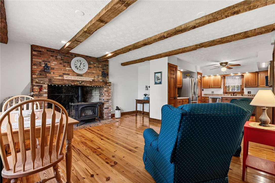 4971 Lackey Road Cedarville, OH 45314 - Photo 21 of 79 This living space features exposed wooden beams and a cozy brick fireplace, creating a warm ambiance.