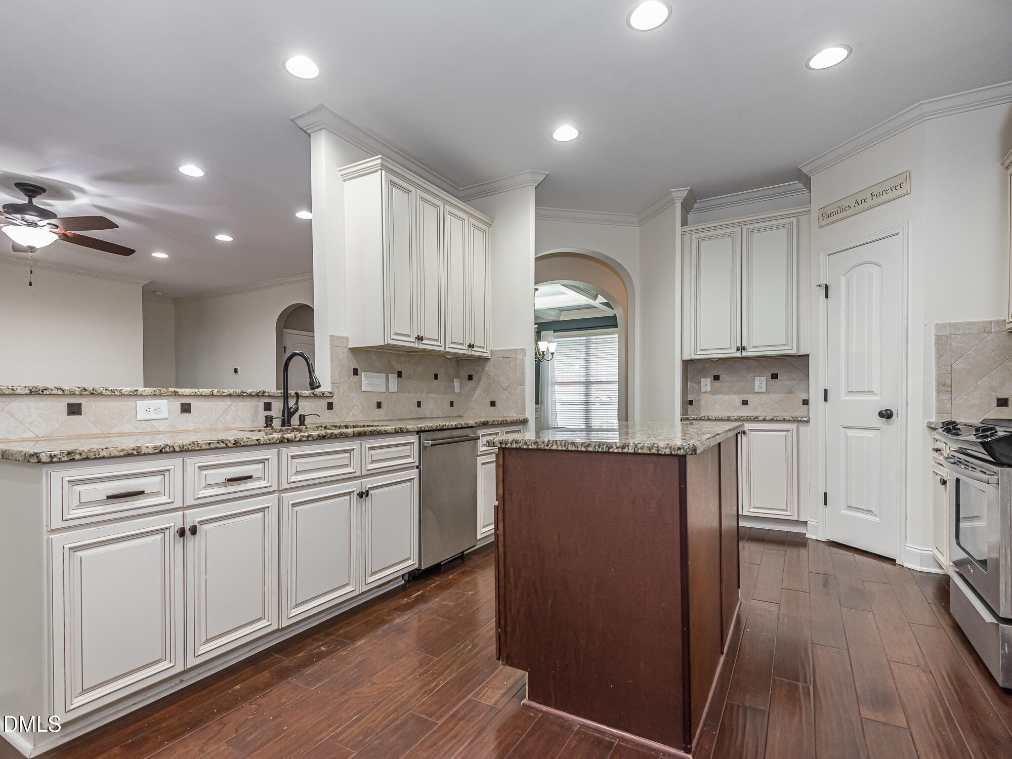 337 Shadowdale Lane Rolesville, NC 27571 - Photo 8 of 42 a kitchen with kitchen island granite countertop wooden floors white cabinets and stainless steel appliances