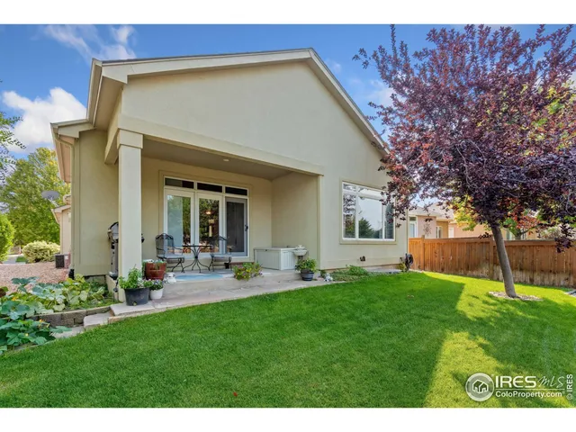 a view of a backyard with table and chairs and wooden fence