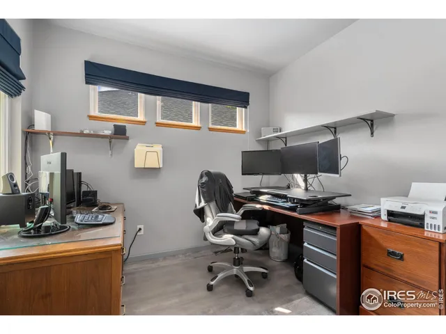 a view of a workspace with furniture and a window