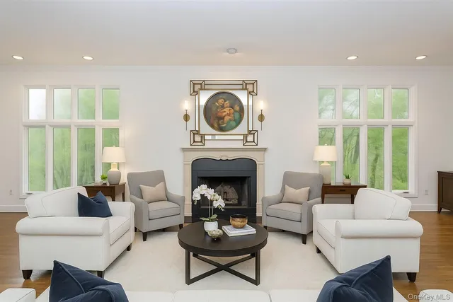 a living room with furniture a fireplace and a large window
