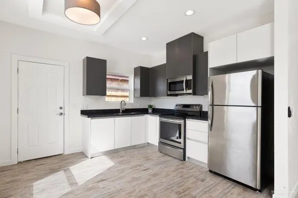a kitchen with stainless steel appliances granite countertop a refrigerator microwave and sink