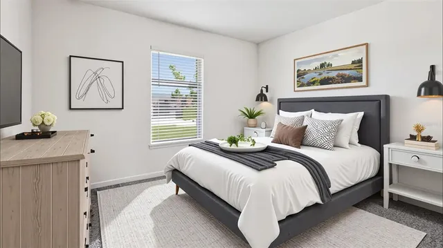 a bed room with a bed and a painting on the wall