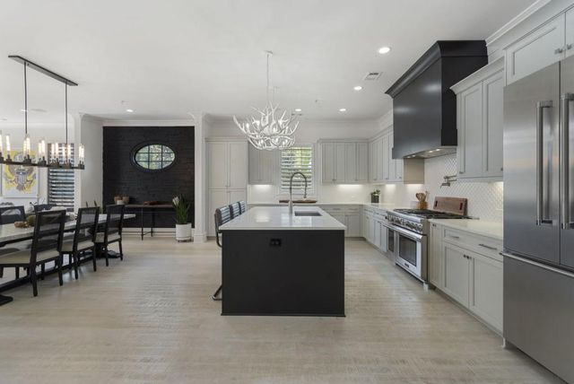 a kitchen with stainless steel appliances granite countertop a sink stove and cabinets
