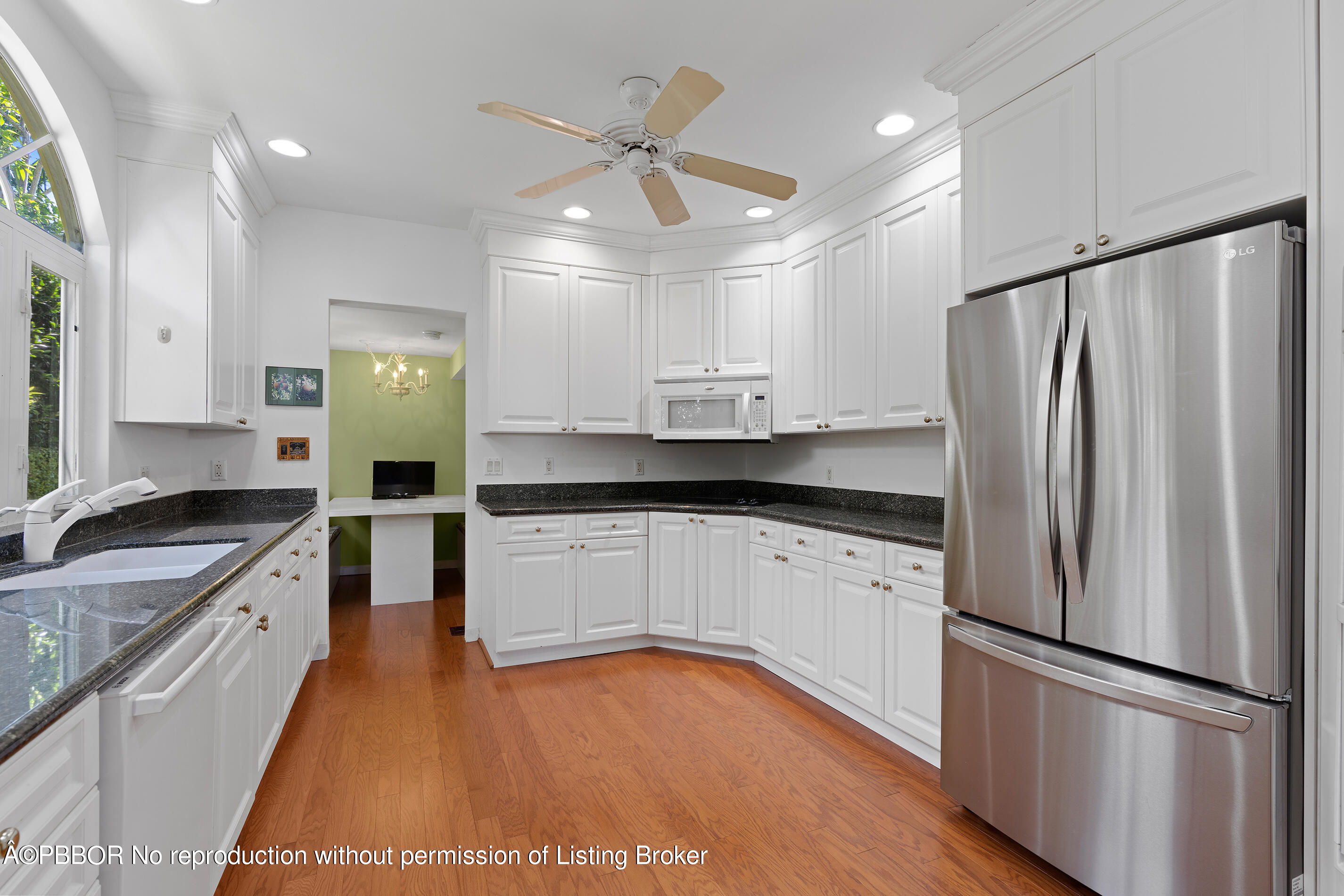 225 South County Road Palm Beach, FL 33480 - Photo 17 of 22 a kitchen with stainless steel appliances granite countertop a refrigerator a sink dishwasher and white cabinets with wooden floor