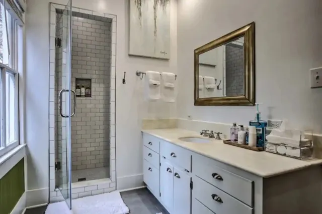 a bedroom with a bed painting on wall and a window