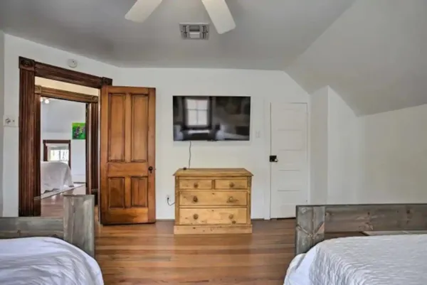 a bedroom with a bed painting on wall and a window