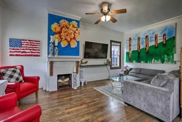 a living room with furniture a flat screen tv and a floor to ceiling window