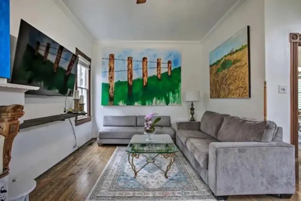 a living room with furniture a flat screen tv and a floor to ceiling window