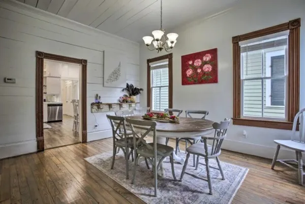 a view of a dining room with furniture a chandelier and wooden floor