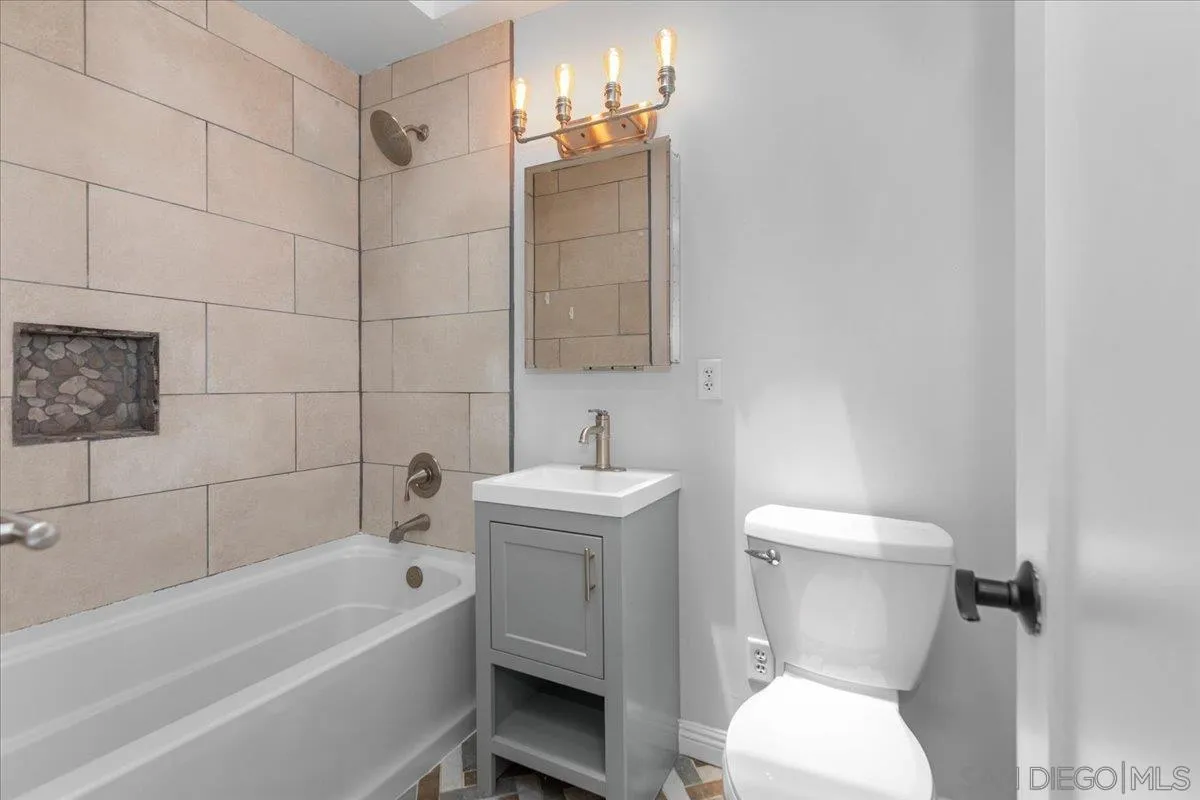 9307 Dalehurst Road Santee, CA 92071 - Photo 13 of 46 a white toilet sitting next to a white bath tub sitting next to a white sink and a shower