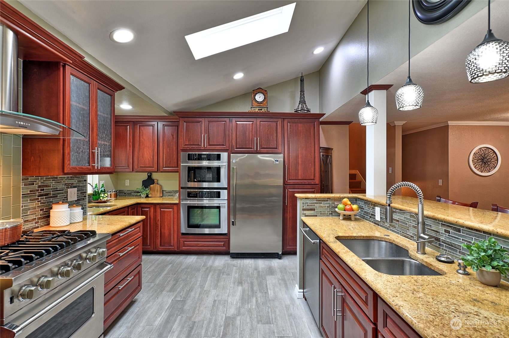 2429 243rd Place Southwest Bothell, WA 98021 - Photo 4 of 40 a kitchen with stainless steel appliances granite countertop a stove a sink dishwasher a refrigerator and a oven with wooden cabinets