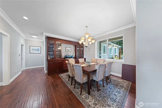 a view of a dining room with furniture a chandelier and wooden floor