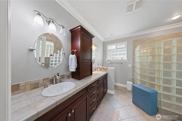 a bathroom with a granite countertop double vanity sink a mirror and a