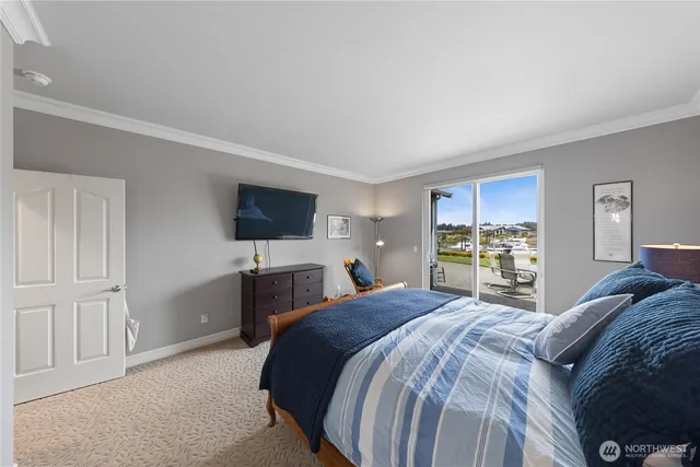 a bedroom with a bed flat screen tv and a window