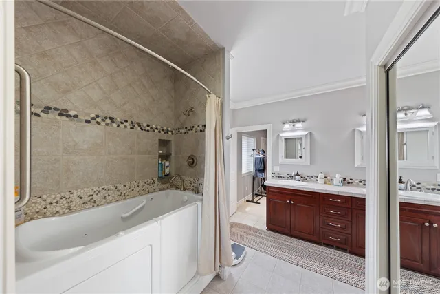 a spacious bathroom with a bathtub sink and mirror