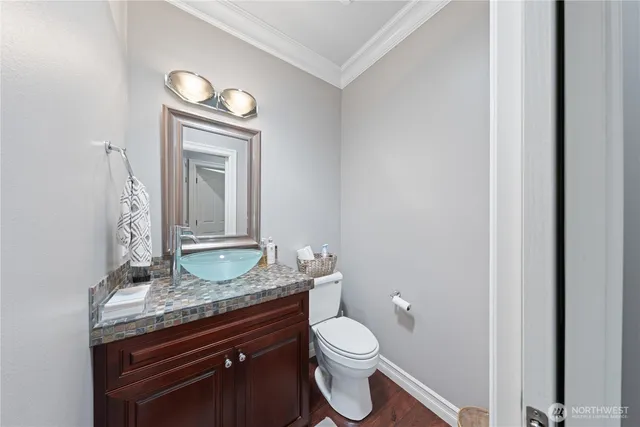 a bathroom with a granite countertop toilet a sink and a mirror
