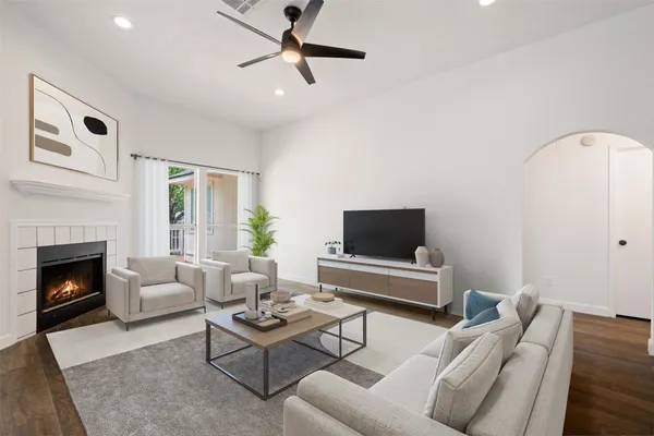 a living room with furniture a fireplace and a flat screen tv